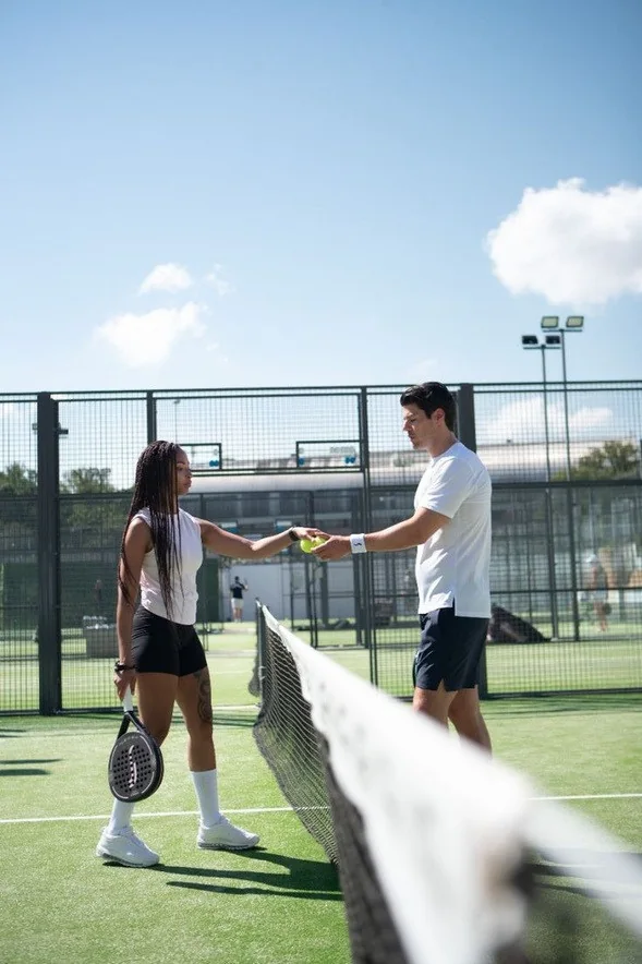 Padel kortunda file yanında buluşan oyuncular